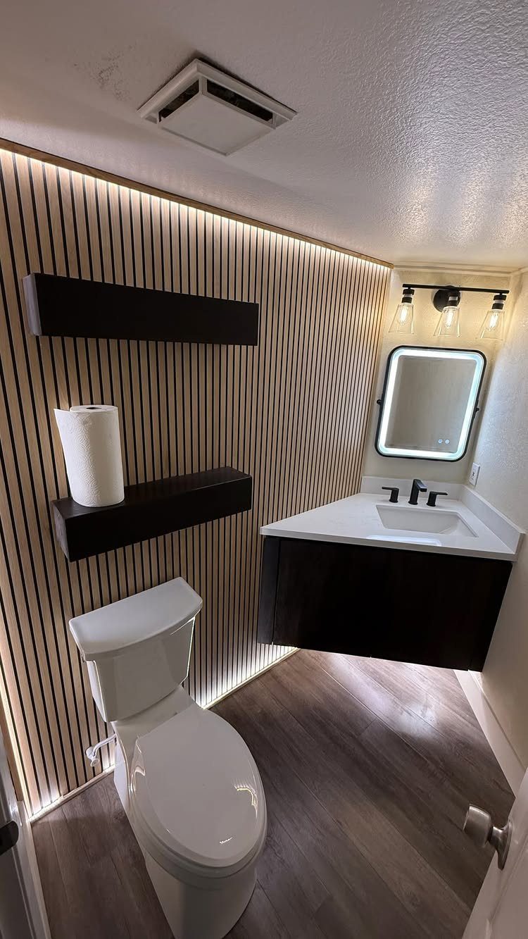 A dark wood floating vanity with a white quartz countertop and integrated sink in a modern bathroom.