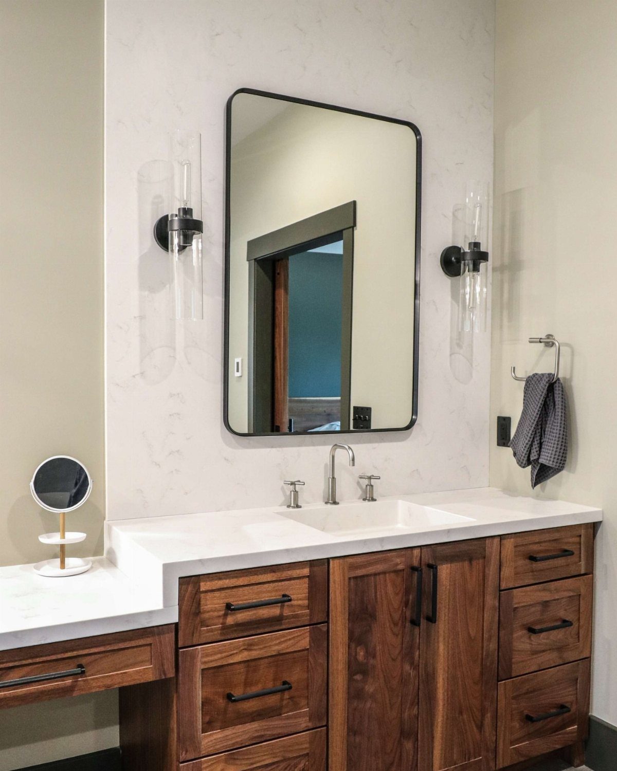 White solid surface bathroom countertop with an integrated sink and dark wood cabinetry.