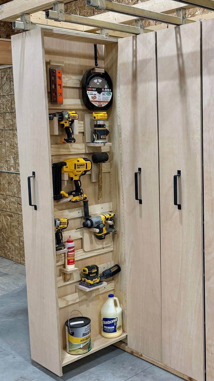 Open wooden cabinet containing various power tools and hardware organized on multiple internal shelves.