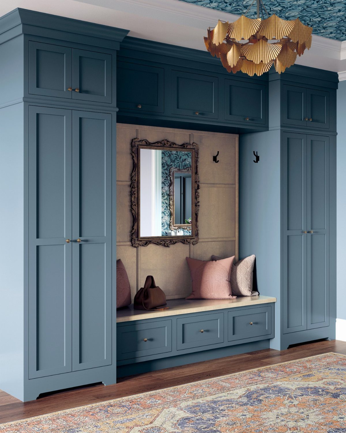 Blue built-in entryway storage unit with wardrobes, a mirror, and a bench with drawers.