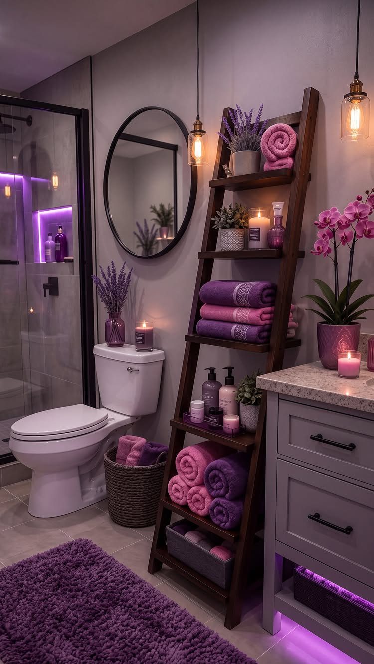 A purple themed bathroom featuring a wooden ladder shelf with rolled towels and decorative candles.