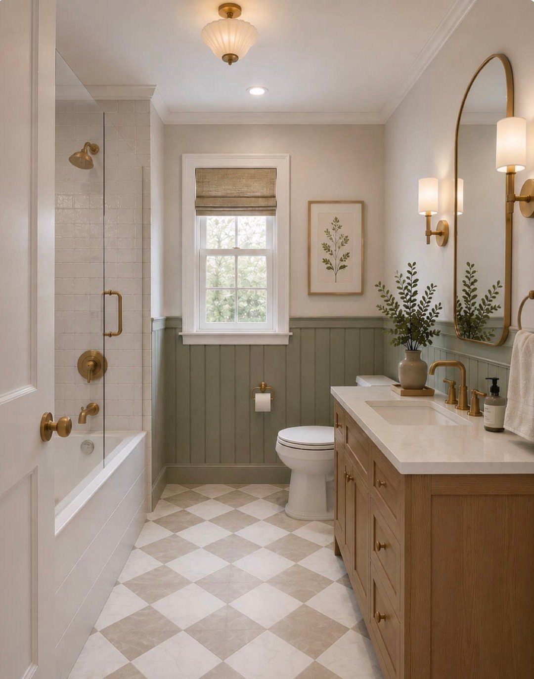 A bright bathroom with a light wood vanity, white toilet, and sage green wainscoting on the walls.