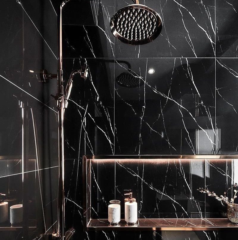 Black marble-patterned tiles covering the walls of a modern shower with chrome fixtures.