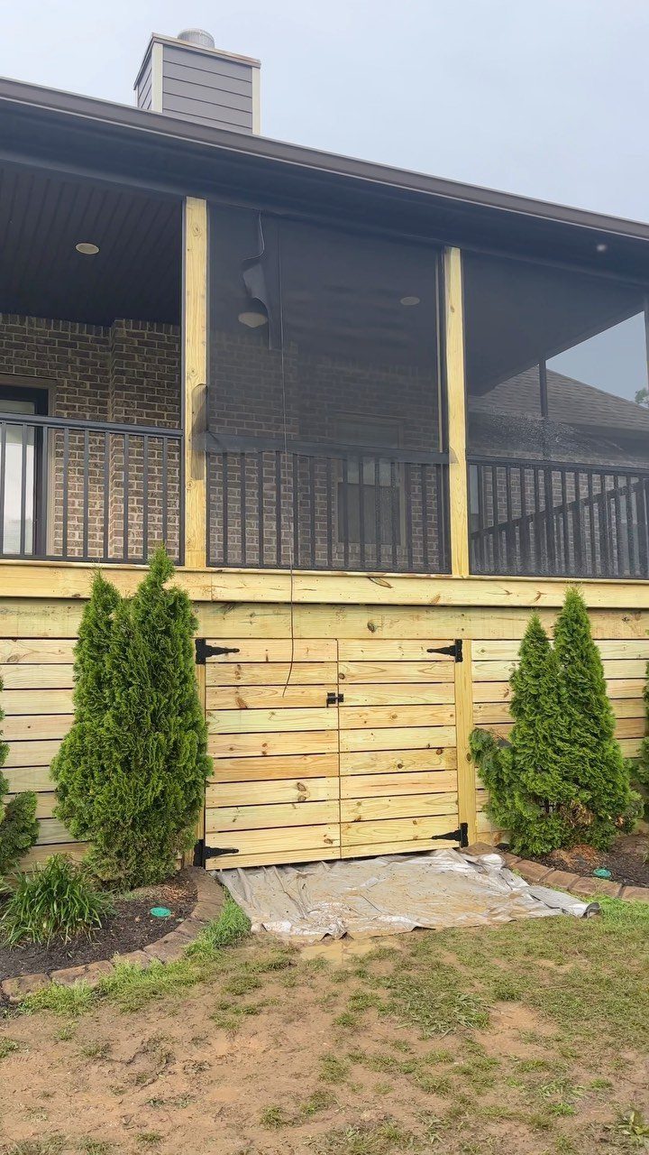 Wooden deck with mesh screening and a built-in storage door underneath the structure.