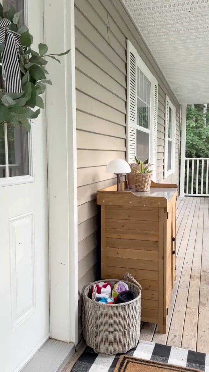 Wooden storage cabinet and woven basket organized on a light-colored wooden porch.