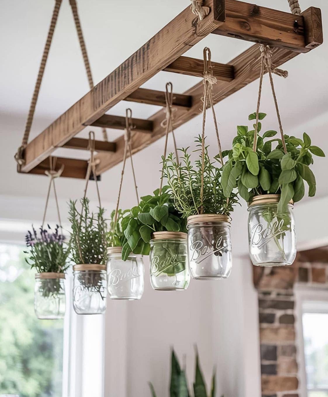 Glass mason jars with green herbs hanging from a wooden ladder rack by twine.