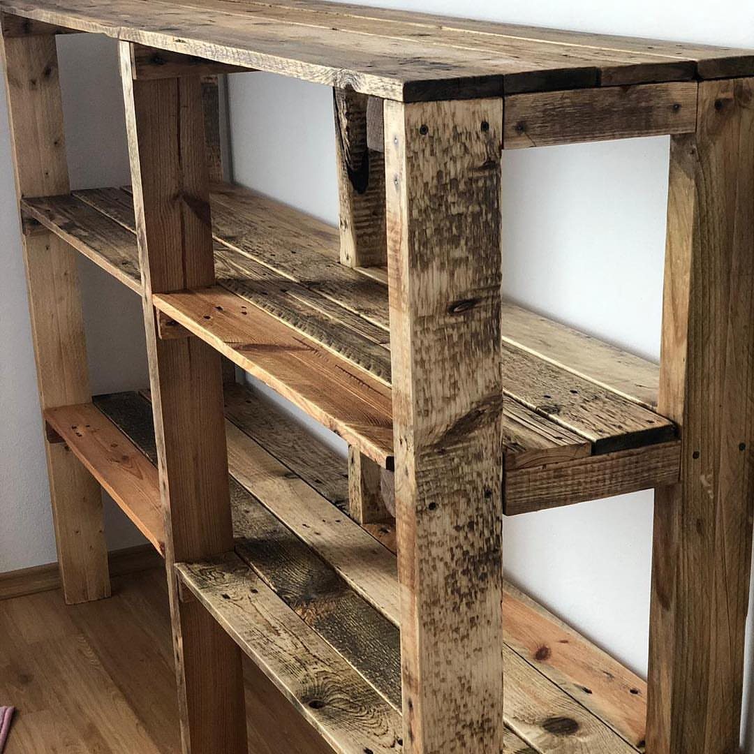 Rustic wooden shelving unit constructed from weathered reclaimed timber planks against a white wall.