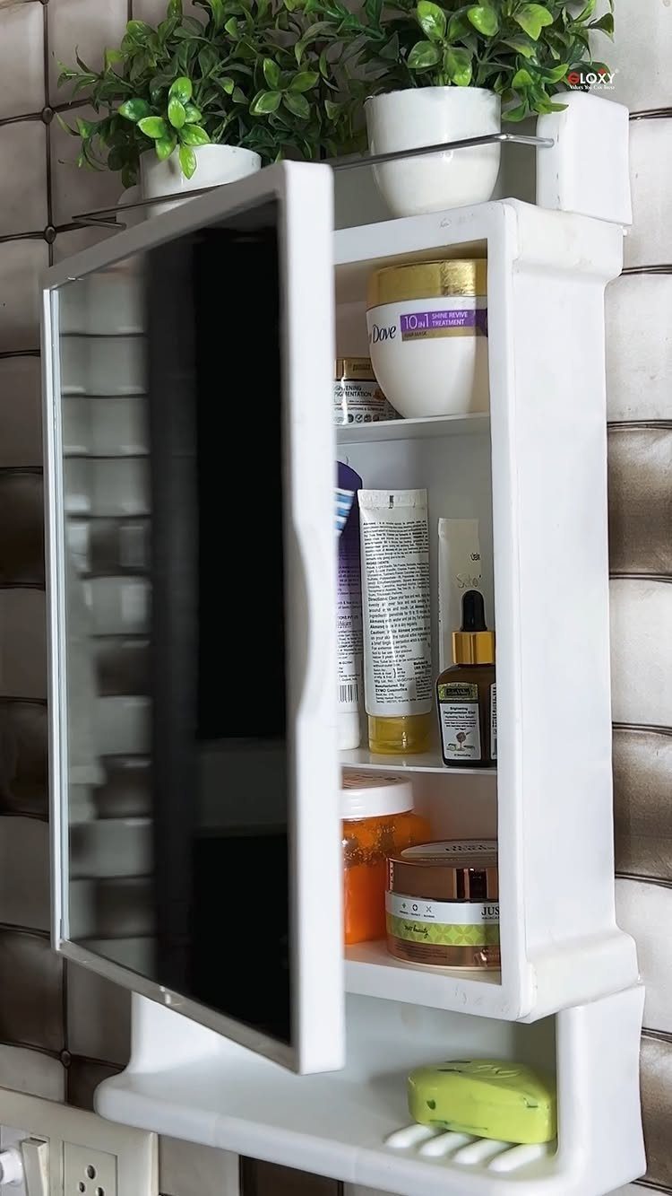 A white wall-mounted medicine cabinet with an open door revealing various skincare products and bottles.
