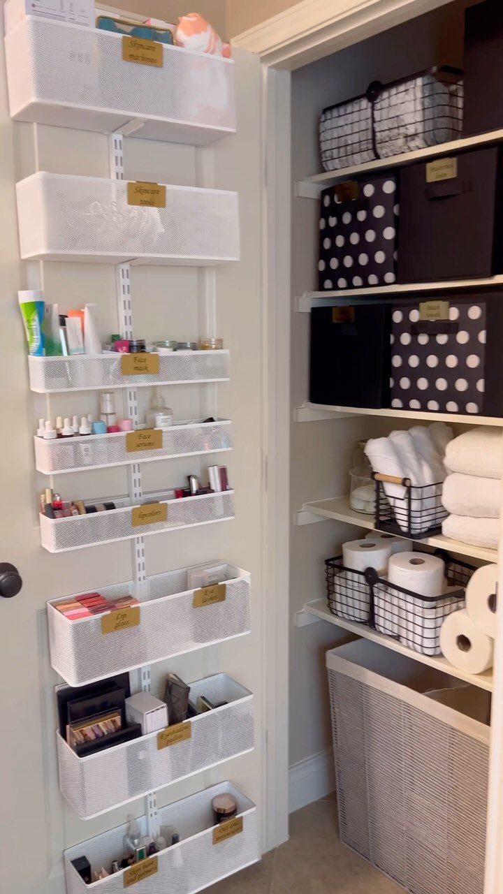 White wire organizers and shelving units filled with toiletries and towels inside a small closet.