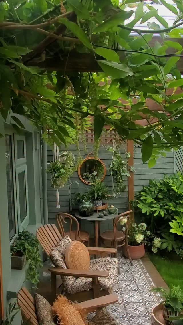 Wooden patio chairs with patterned pillows and cushions arranged on a small outdoor deck.