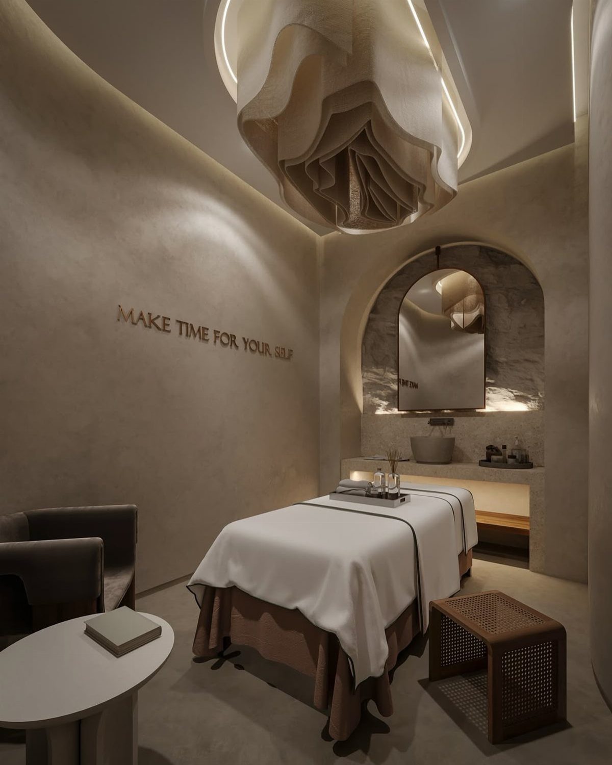 A minimalist spa treatment room featuring a massage table and an arched sink alcove.