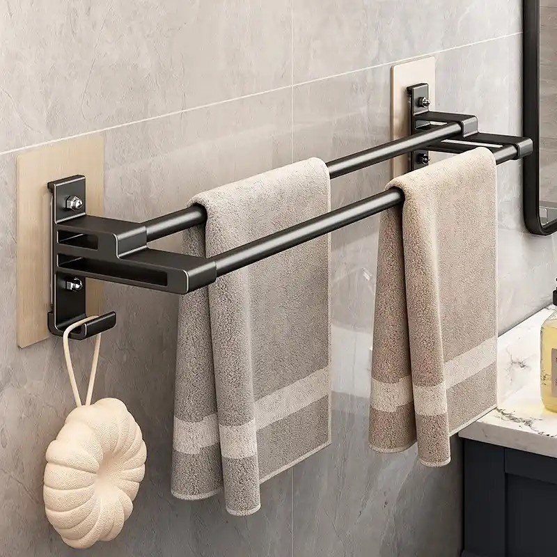 Black metal double towel rod with grey towels hanging on a grey tiled bathroom wall.