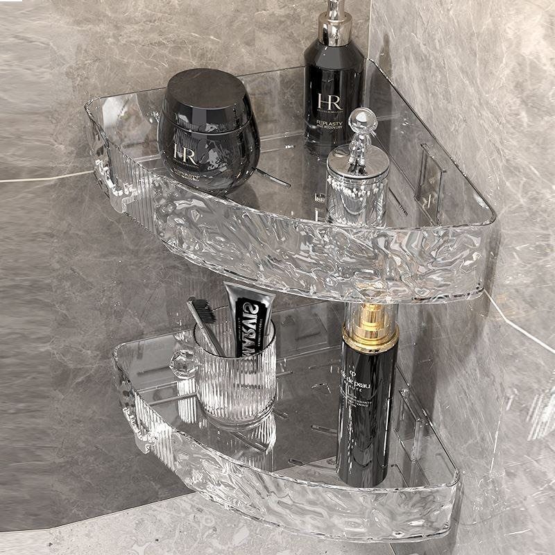 Clear acrylic corner shelves holding various cosmetic bottles and toiletries on a marble wall.