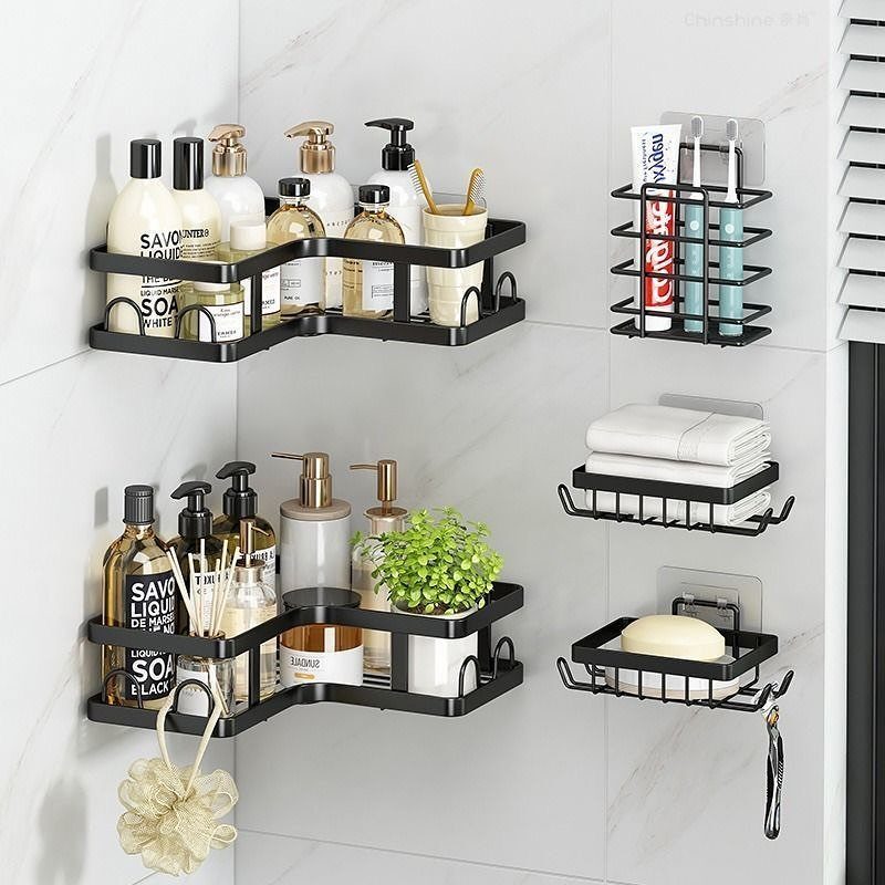 Black wire bathroom shelves mounted on a marble wall holding various toiletries and a small green plant.