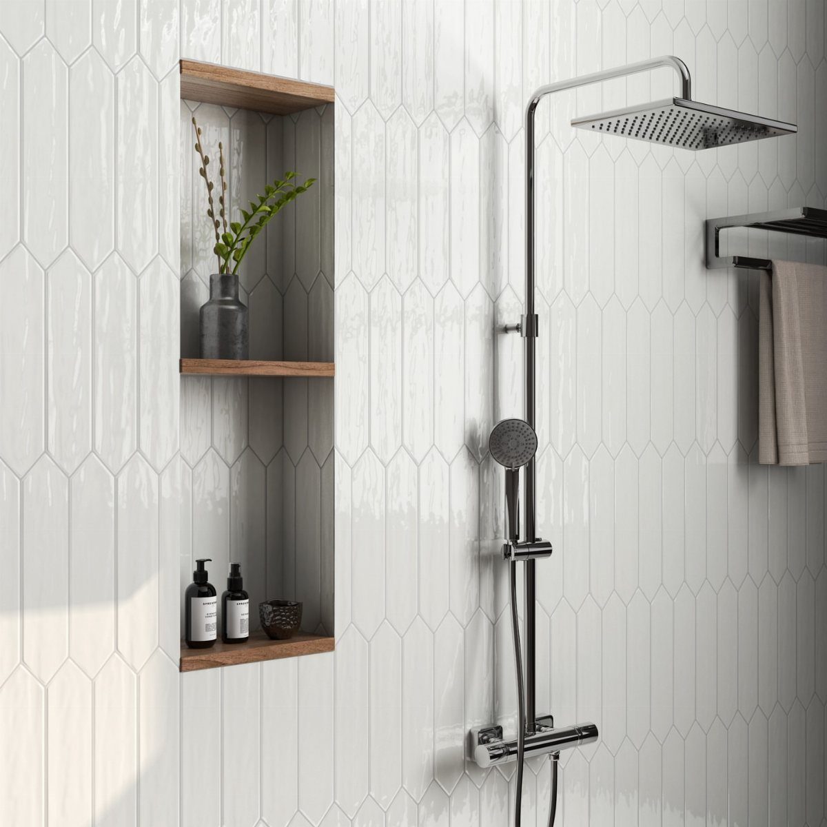 White picket-shaped porcelain tiles on a bathroom wall with a chrome shower fixture and wooden niche.