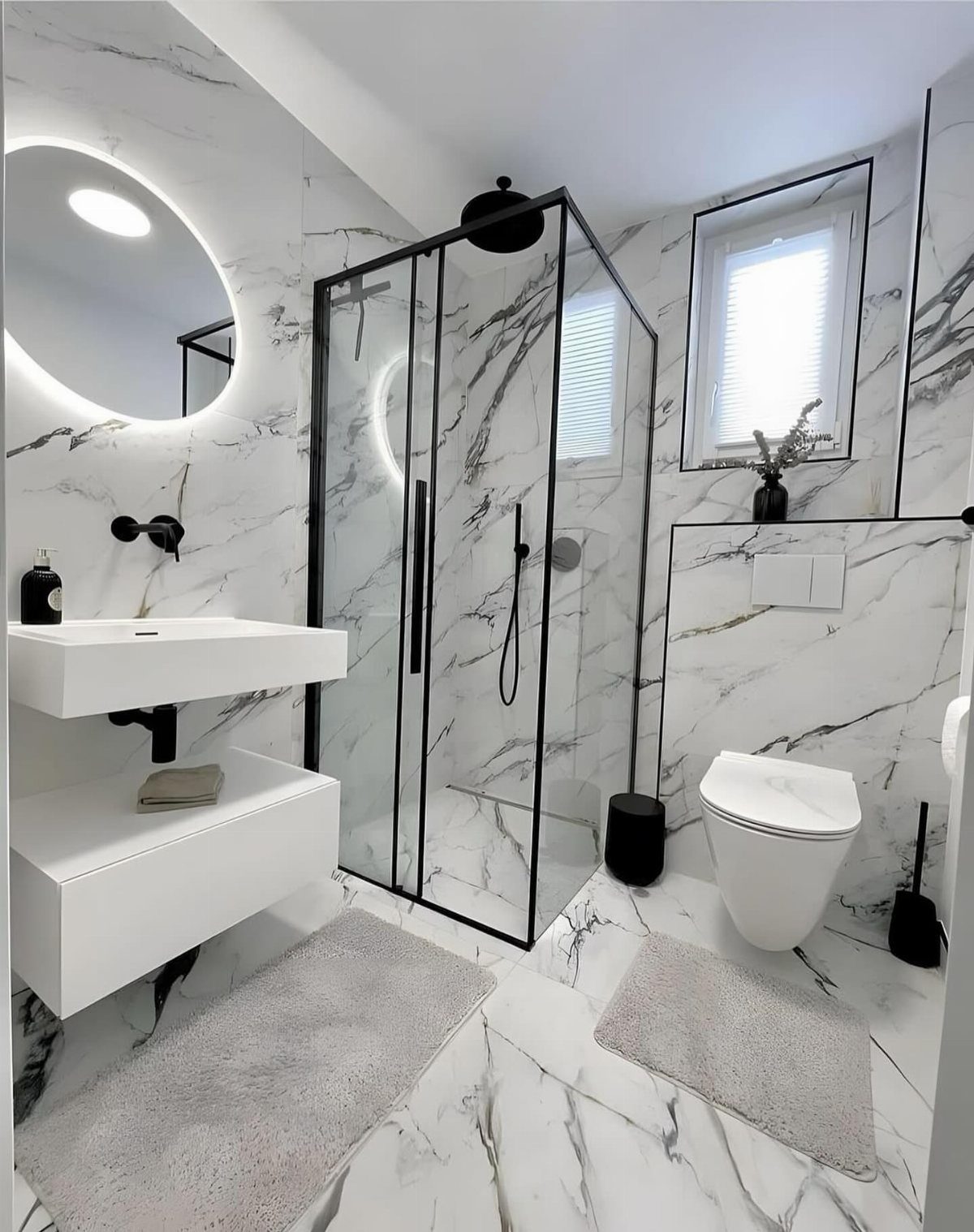 Modern bathroom with white marble tiles on the walls and floor featuring black fixtures.